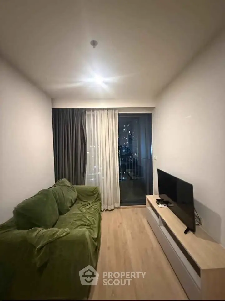 Cozy living room with modern decor and city view from balcony.
