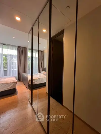 Spacious bedroom with mirrored closet and large windows for natural light