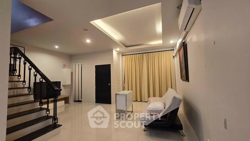 Spacious modern living room with elegant staircase and cozy seating area