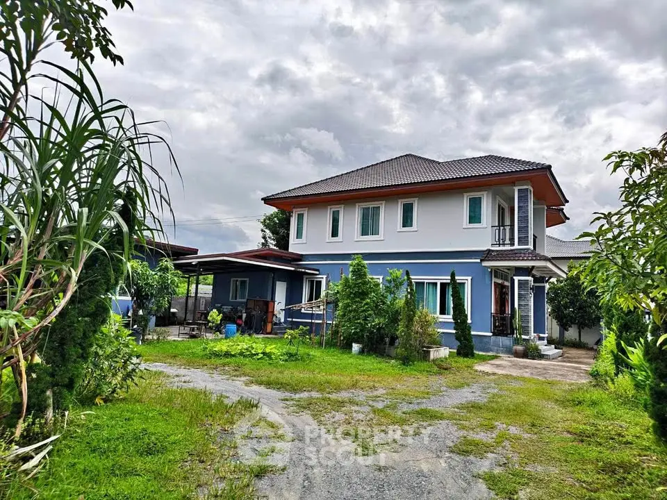 Charming two-story house with lush garden and spacious driveway under cloudy sky.