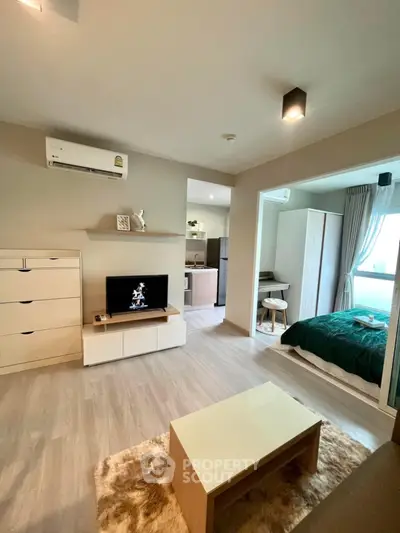 Modern open-plan living room with cozy bedroom, stylish decor, and natural light.