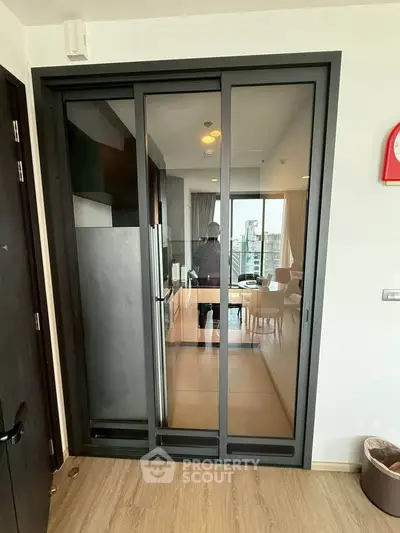 Modern apartment with sliding glass doors leading to a stylish living area with city view.