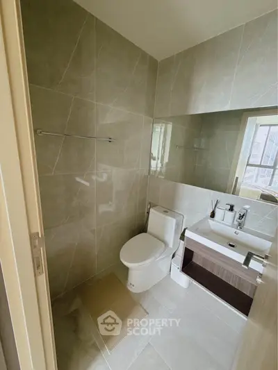 Modern bathroom with sleek design and large mirror in a contemporary apartment.