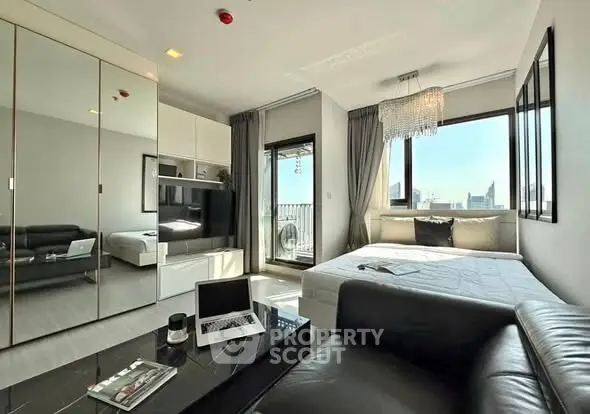 Modern studio apartment with sleek design and city view, featuring a cozy living area and stylish decor.