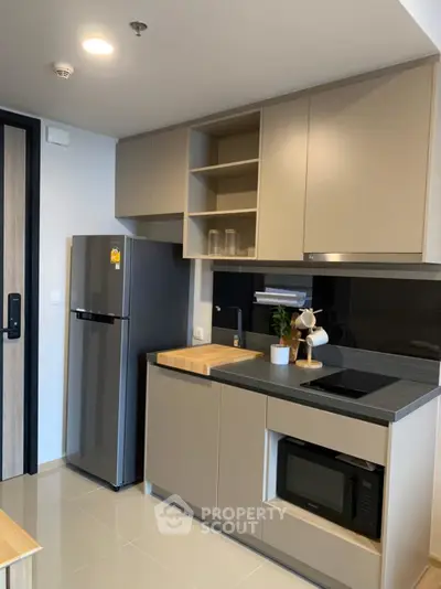 Modern kitchen with sleek cabinetry, built-in appliances, and stylish decor in a contemporary apartment.