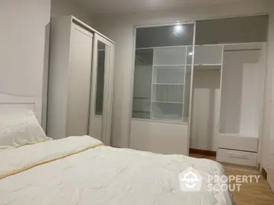 Spacious bedroom with modern wardrobe and cozy bedding, perfect for relaxation and comfort.