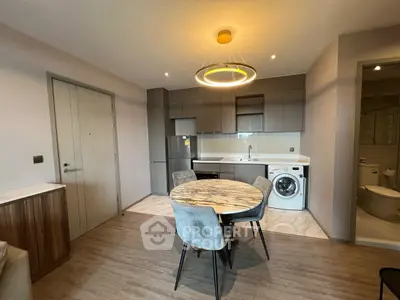 Modern kitchen with dining area and washing machine in stylish apartment