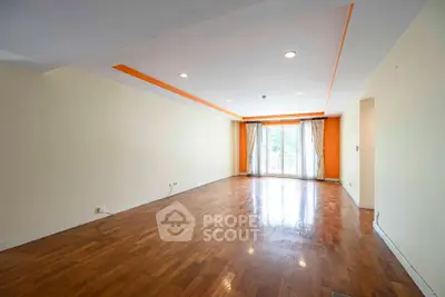 Spacious empty living room with wooden flooring and large windows