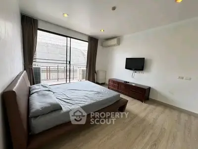 Spacious bedroom with modern furnishings and balcony access in a stylish apartment.