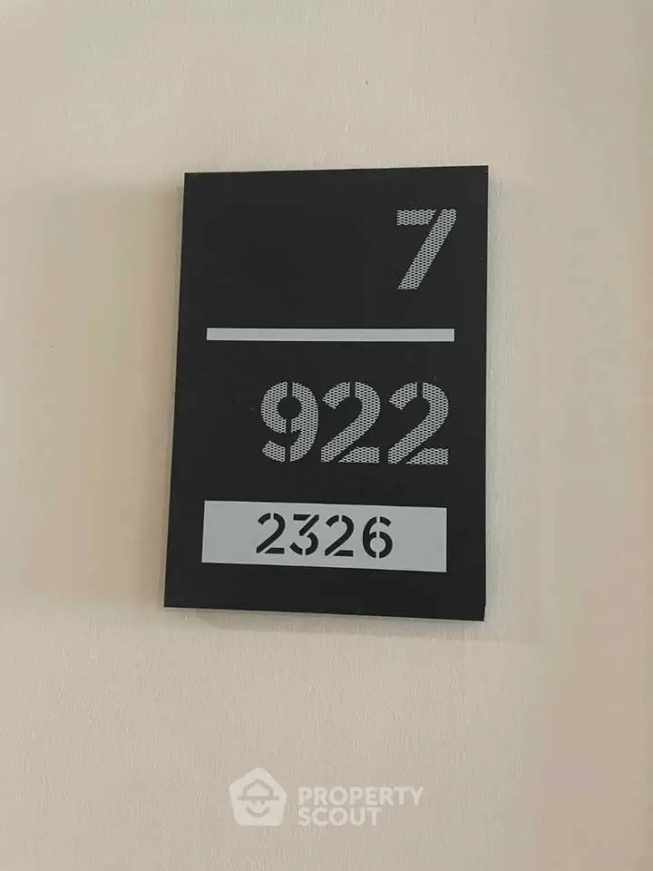 Modern apartment number sign with sleek design on a neutral wall, indicating unit 922 on floor 7.