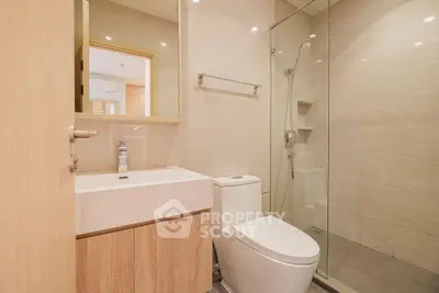 Modern bathroom with glass shower and sleek fixtures in a contemporary apartment.