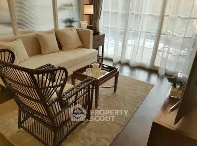 Elegant living room with natural light, cozy sofa, and stylish wicker chair.