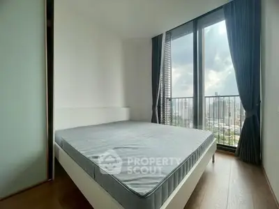Modern bedroom with large windows offering stunning city views and ample natural light.