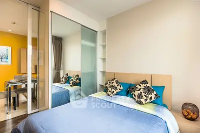 Modern bedroom with stylish decor and mirrored closet doors in a cozy apartment.