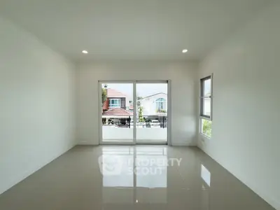 Spacious unfurnished room with large windows and glossy tiled floor, offering a bright and airy atmosphere.