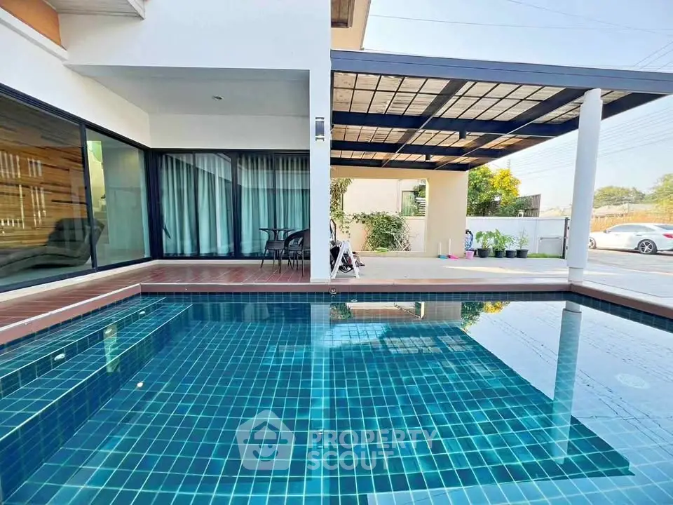 Modern home with stylish poolside area and covered patio, perfect for relaxation and entertainment.