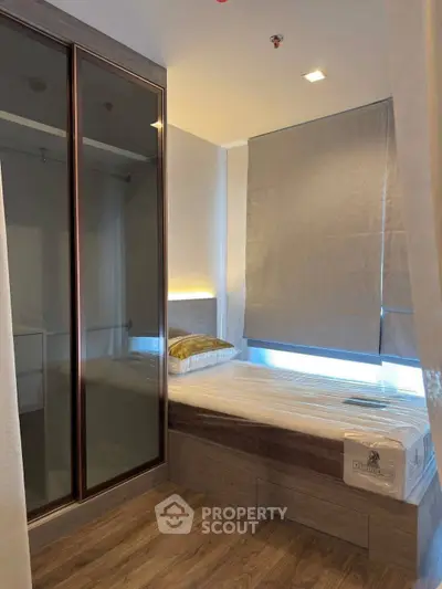 Modern bedroom with sleek design, featuring a built-in wardrobe and cozy bed, perfect for urban living.