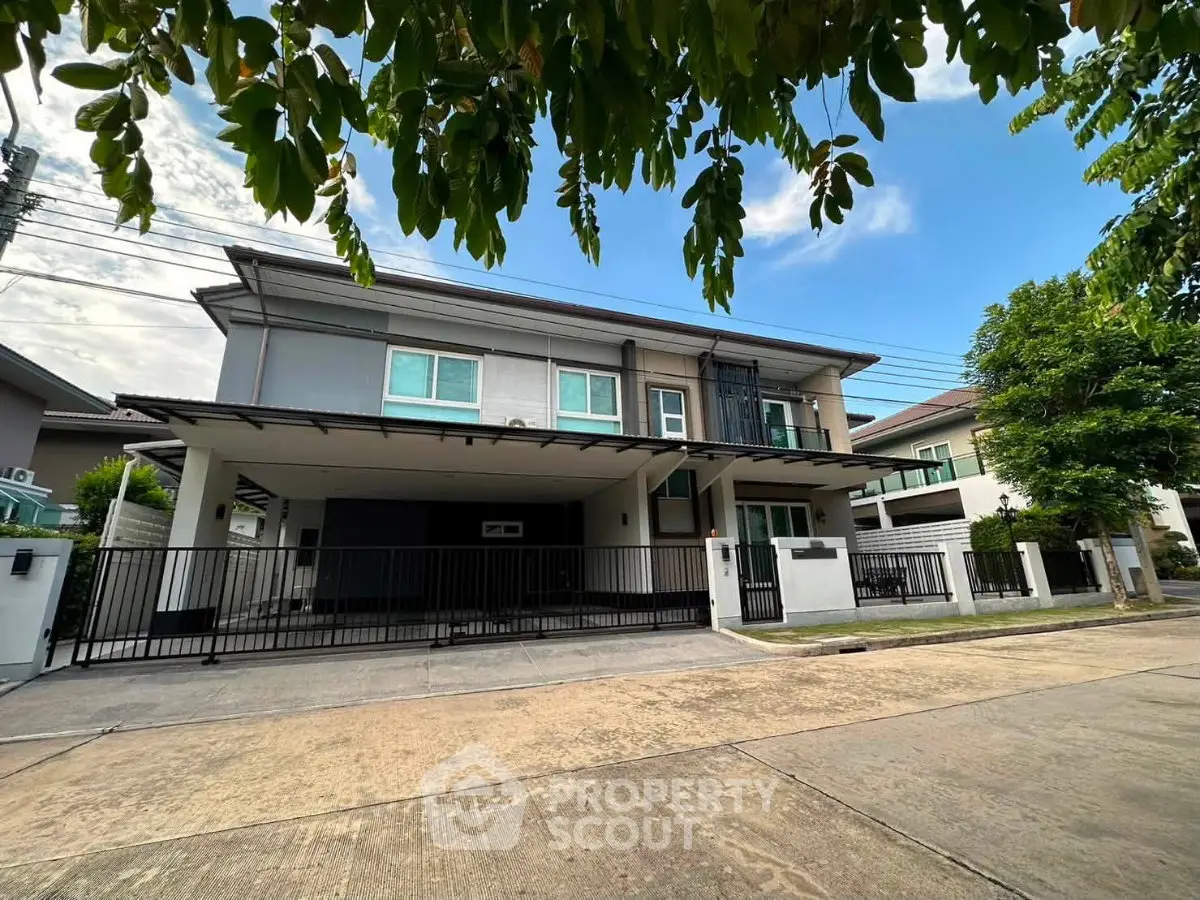 Modern two-story house with spacious driveway and lush greenery in a serene neighborhood.