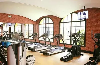 Spacious gym with modern equipment and large windows in luxury property.