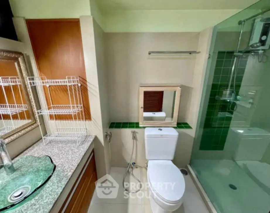 Modern bathroom with glass shower and stylish sink in real estate property