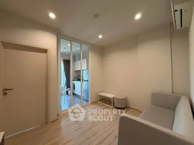 Modern living room with minimalist decor and open view to kitchen area