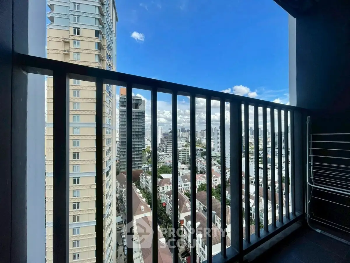 Stunning high-rise balcony view overlooking city skyline with clear blue skies.