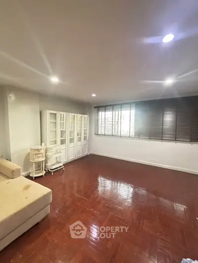 Spacious living room with hardwood floors and ample natural light, perfect for relaxation and entertainment.