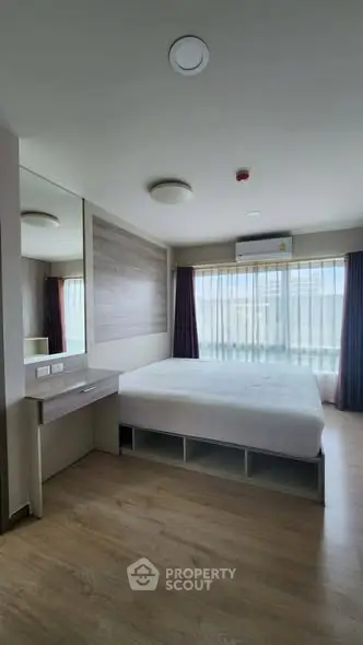 Modern bedroom with large window and minimalist design in a stylish apartment.