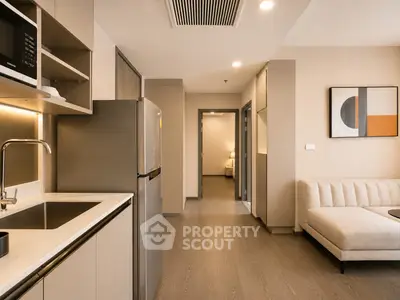 Modern open-layout kitchen and living room with sleek design and neutral tones.