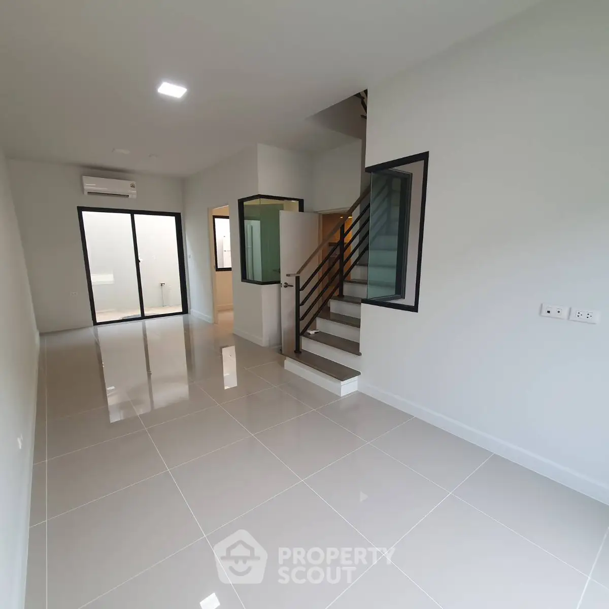 Modern townhouse interior with sleek staircase and glossy tiled flooring