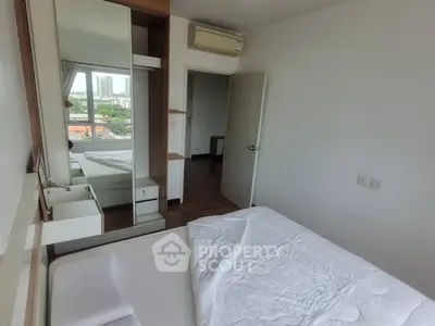 Bright bedroom with large mirror and city view, featuring modern air conditioning and wooden flooring.