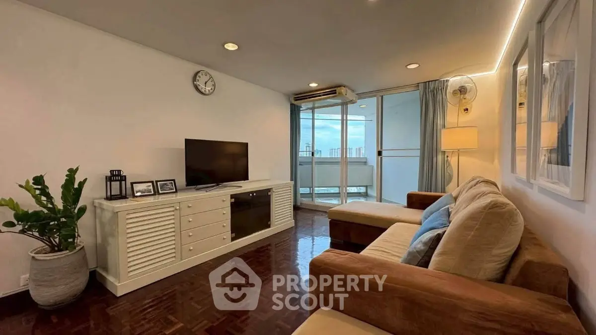 Spacious living room with modern decor and balcony view in high-rise apartment.