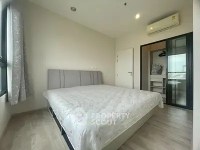 Modern bedroom with large bed and ensuite bathroom in a stylish apartment.