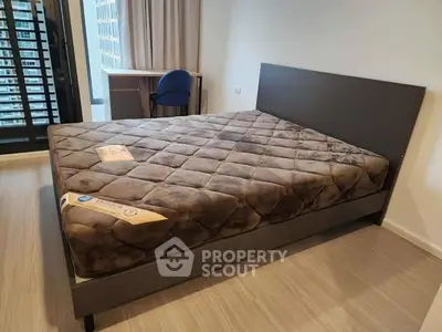 Spacious bedroom with modern bed and city view balcony access.