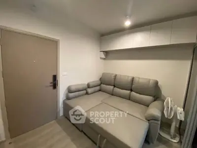 Cozy living room with modern gray sofa and sleek storage cabinets.