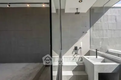 Modern minimalist bathroom with sleek gray tiles and contemporary fixtures