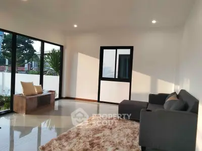 Spacious modern living room with large windows and cozy seating area.