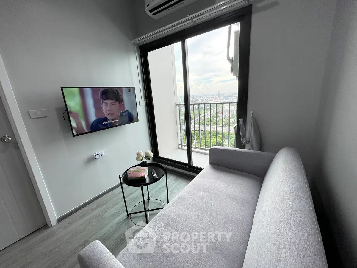 Modern living room with balcony view and wall-mounted TV in stylish apartment.