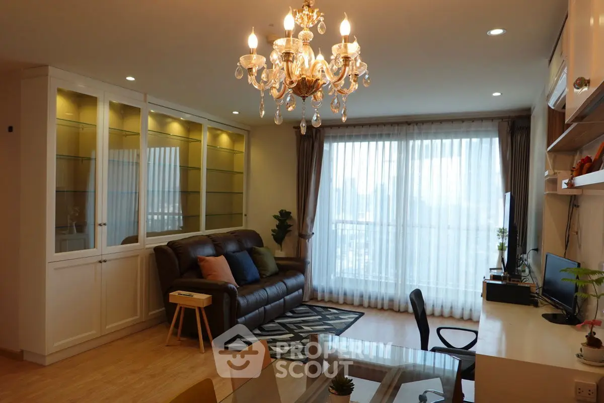 Elegant living room with chandelier and city view, perfect for modern living.