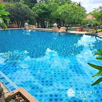 Luxurious outdoor swimming pool with lush greenery and serene ambiance