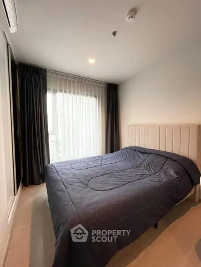 Cozy bedroom with modern design and large window for natural light.