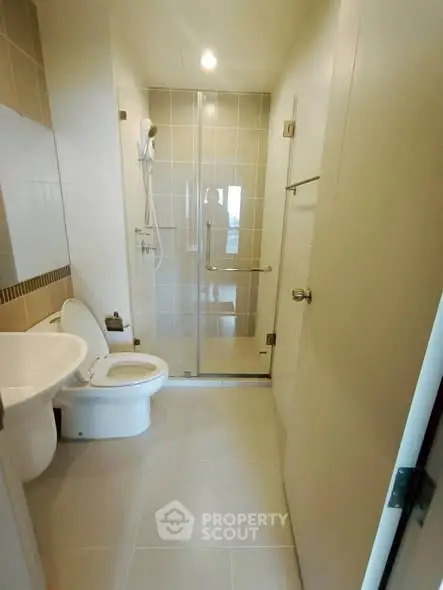 Modern bathroom with glass shower and sleek fixtures in a contemporary apartment.