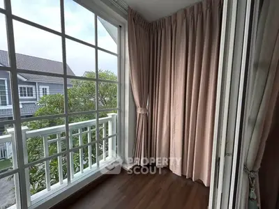 Charming balcony with elegant curtains and scenic view, perfect for relaxation and enjoying the outdoors.