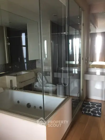 Luxurious modern bathroom with glass shower and bathtub in stylish apartment.