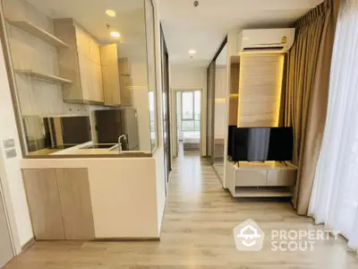 Modern apartment interior with open kitchen and living area, featuring sleek design and natural light.