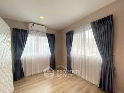 Bright bedroom with large windows and elegant curtains in modern home.