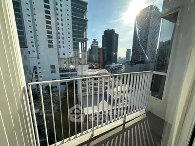 Modern city view from high-rise balcony with sleek railing design.