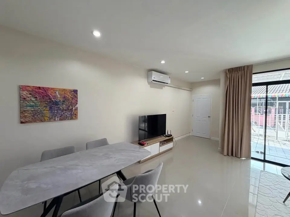 Modern living room with dining area and sliding glass doors to balcony