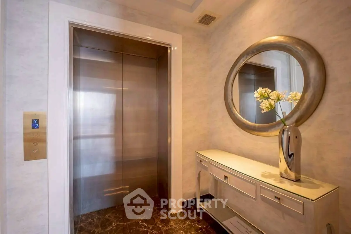 Elegant elevator lobby with modern decor and stylish mirror