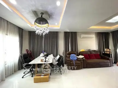 Spacious living room with elegant chandelier and modern furnishings